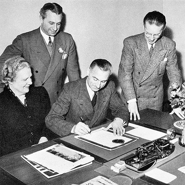 Luise und Hans Baumgartner-Ehrsam (in der Mitte) unterzeichnen Fabrikverträge in Anwesenheit von zwei befreundeten Studebaker-Vertretern.